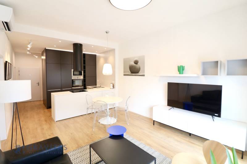 Komfortne vybavený 2-izbový byt v projekte 2 Sýpky - Obývačka s kuchynským kútom, podlaha s dreveným dekorom, 2-izbový byt, svetlý interiér.