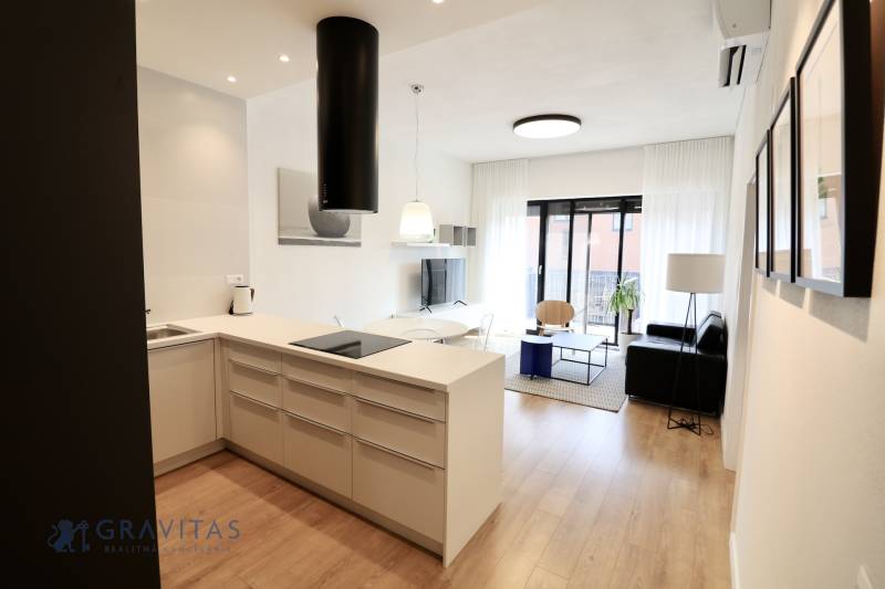 Komfortne vybavený 2-izbový byt v projekte 2 Sýpky - Kuchyňa s ostrovčekom a obývačka, podlaha s dreveným dekorom, 2-izbový byt.