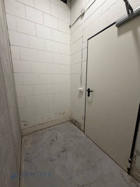 Komfortne vybavený 2-izbový byt v projekte 2 Sýpky - Malá miestnosť s betónovou podlahou a bielymi tehlovými stenami v 2-izbovom byte.