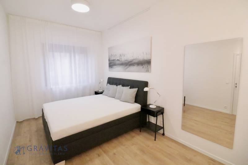 Komfortne vybavený 2-izbový byt v projekte 2 Sýpky - Svetlá spálňa s veľkým lôžkom a podlahou s dreveným dekorom v 2-izbovom byte.