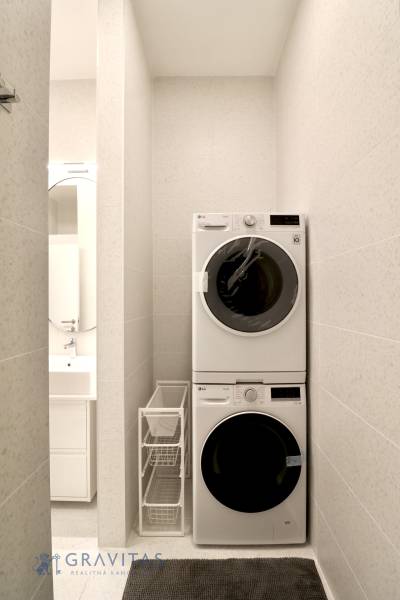 Komfortne vybavený 2-izbový byt v projekte 2 Sýpky - Práčka a sušička v úzkej kúpeľni, vedľa skrinky s umývadlom v 2-izbovom byte.