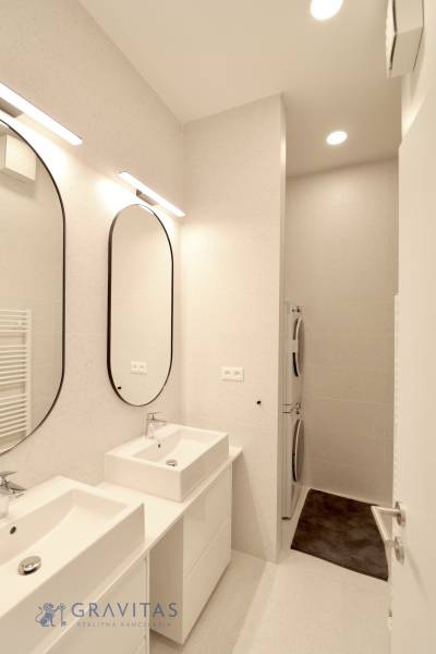 Komfortne vybavený 2-izbový byt v projekte 2 Sýpky - Kúpeľňa v 2-izbovom byte s dvomi umývadlami, veľkými zrkadlami a pračkou.