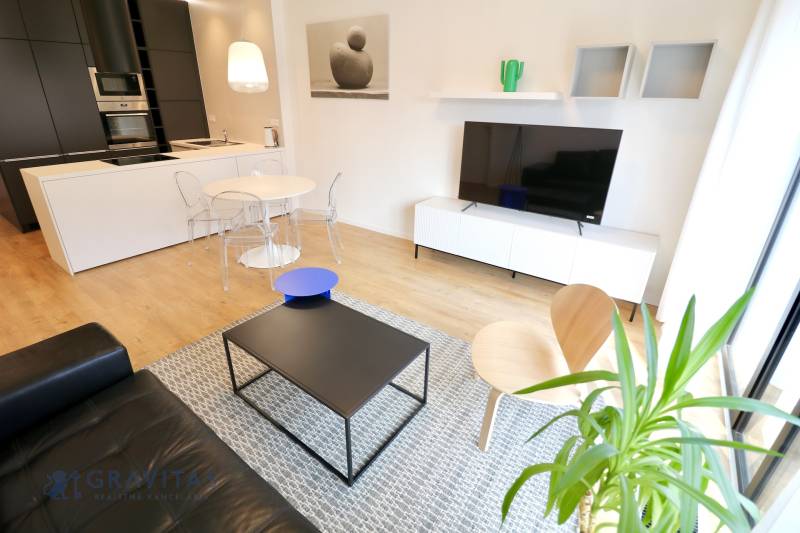 Komfortne vybavený 2-izbový byt v projekte 2 Sýpky - Obývačka s podlahou s dreveným dekorom a moderným nábytkom v 2-izbovom byte.