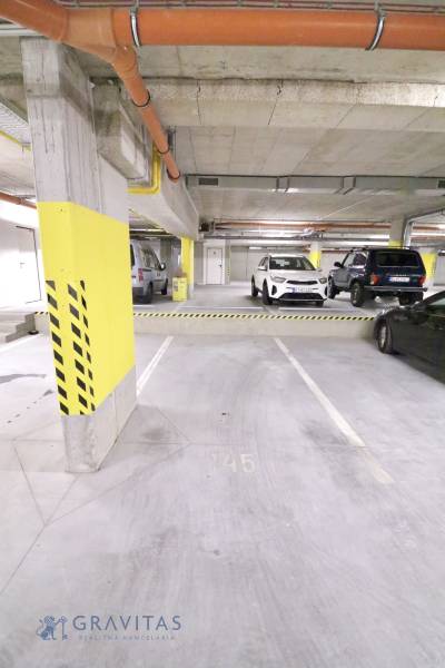 Komfortne vybavený 2-izbový byt v projekte 2 Sýpky - Podzemné parkovisko s označenými miestami a odstavenými vozidlami.