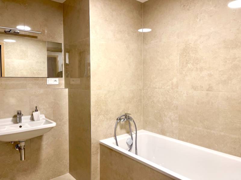 I 3 i byt s parkovaním v rezidenčnom komplexe METROPOLIS - Kúpeľňa s vaňou a umývadlom s neutrálnymi obkladmi v 3-izbovom byte.