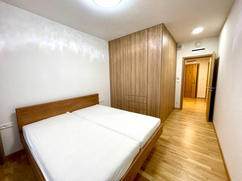 I 3 i byt s parkovaním v rezidenčnom komplexe METROPOLIS - Spálňa v 3-izbovom byte s podlahou s dreveným dekorom a vstavanou skriňou.