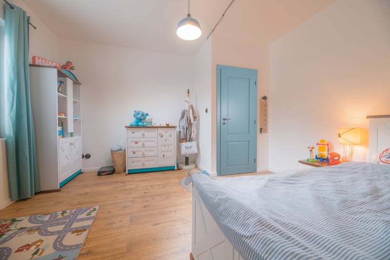 Na predaj zrekonštruovaný dom na Štefánikovej ulici, Trenčín - Detská izba v rodinnom dome s nábytkom a podlahou s dreveným dekorom.