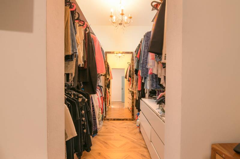 Na predaj zrekonštruovaný dom na Štefánikovej ulici, Trenčín - Šatník v Rodinnom dome s vešiakmi a komodami na podlahe s dreveným dekorom.