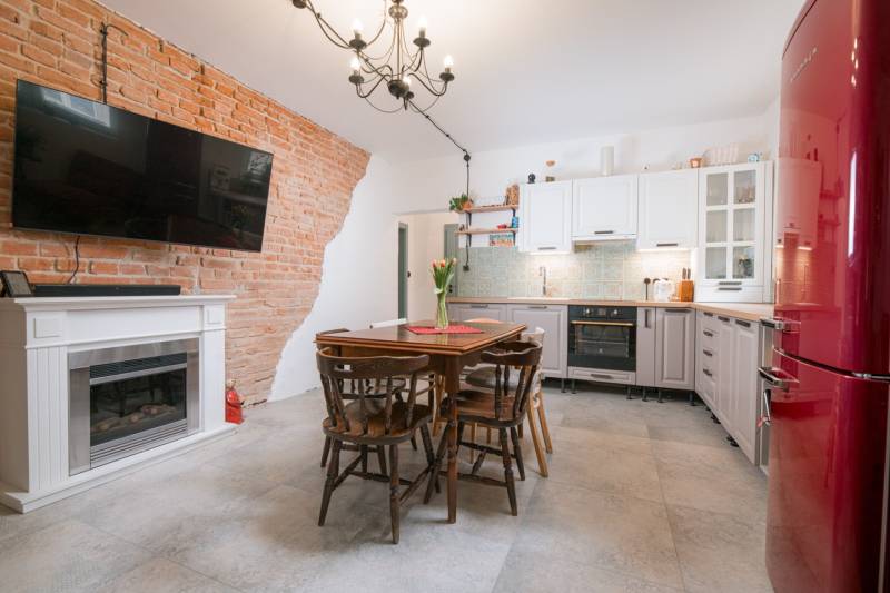 Na predaj zrekonštruovaný dom na Štefánikovej ulici, Trenčín - Kuchyňa v rodinnom dome s tehlovou stenou, kachľami a dreveným nábytkom.