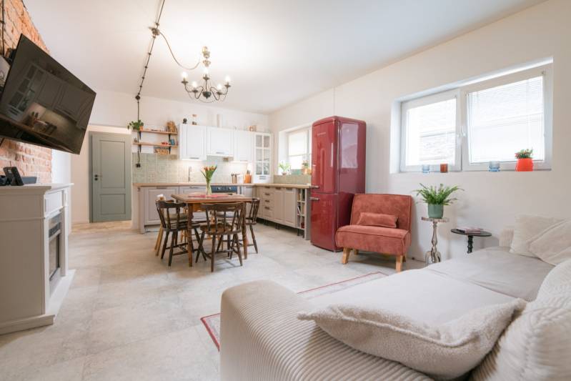 Na predaj zrekonštruovaný dom na Štefánikovej ulici, Trenčín - Obývacia izba a kuchyňa v rodinnom dome s jedálenským stolom a červenou chladničkou.