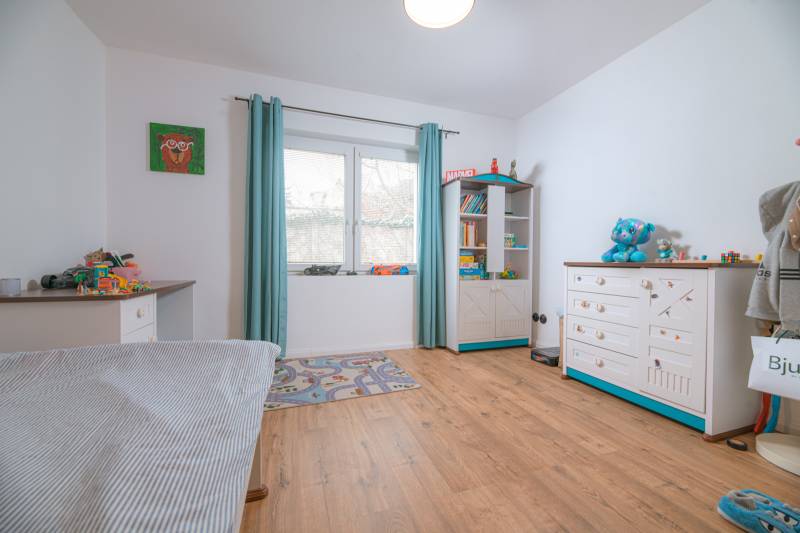 Na predaj zrekonštruovaný dom na Štefánikovej ulici, Trenčín - Detská izba s podlahou s dreveným dekorom a hračkami v rodinnom dome.