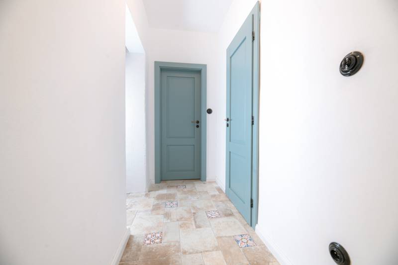 Na predaj zrekonštruovaný dom na Štefánikovej ulici, Trenčín - Chodba v rodinnom dome s modrými dverami a dlažbou s dekorom.