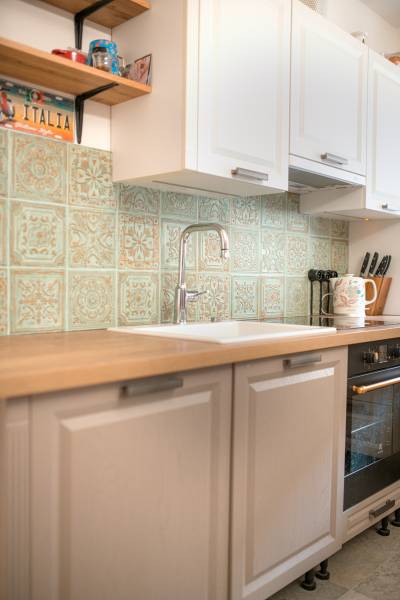 Na predaj zrekonštruovaný dom na Štefánikovej ulici, Trenčín - Kuchyňa v rodinnom dome s vintage obkladom a dreveným dekorom pracovnej dosky.