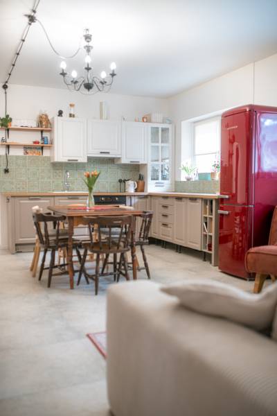 Na predaj zrekonštruovaný dom na Štefánikovej ulici, Trenčín - Kuchyňa v rodinnom dome s dreveným stolom a červenou chladničkou.