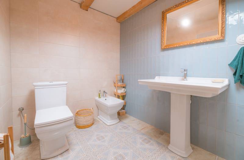 Na predaj zrekonštruovaný dom na Štefánikovej ulici, Trenčín - Kúpeľňa v rodinnom dome s toaletou, bidetom, umývadlom a zrkadlom v zlatej ráme.