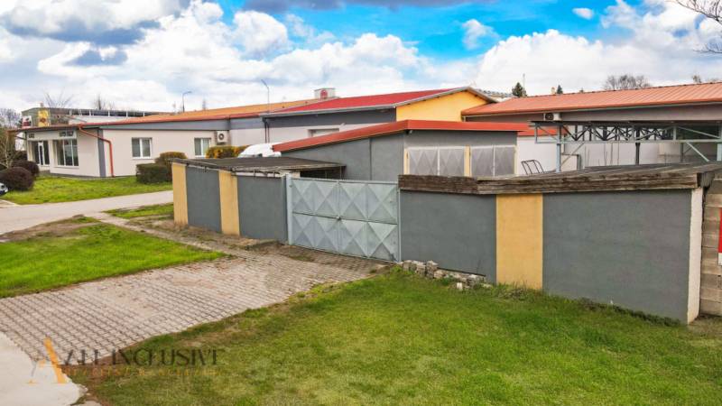 PRAKTICKÉ SKLADOVÉ PRIESTORY  | DOPRAVNÁ | TOPOĽČANY - Priemyselný areál s bránou, budovy na ulici Dopravná, vhodný pre sklady a haly.