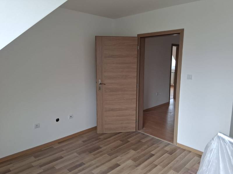 PREDAJ – 4-izbový rodinný dom v radovej zástavbe s garážou - Izba v Rodinnom dome s podlahou s dreveným dekorom a drevenými dverami.