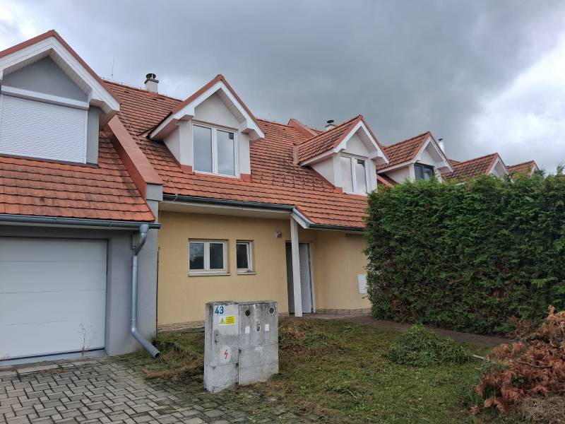 PREDAJ – 4-izbový rodinný dom v radovej zástavbe s garážou - Rodinný dom v Ľubeli s červenou strechou, garážou a udržiavanou záhradou.