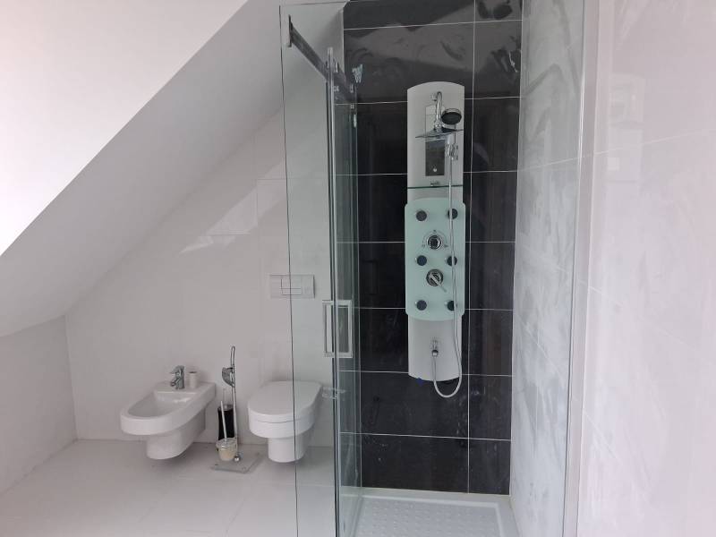 PREDAJ – 4-izbový rodinný dom v radovej zástavbe s garážou - Kúpeľňa v rodinnom dome s toaletou, bidetom a sprchovým kútom pod zošikmenou stenou.