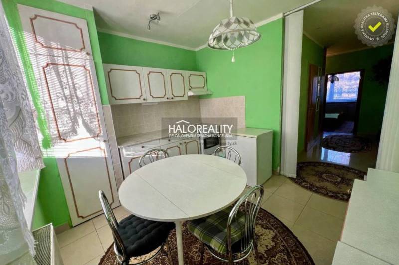 REZERVOVANÉ - Predaj, trojizbový byt Bojnice, Lúčky ... - Kuchyňa so zelenými stenami a nábytkom v 3-izbovom byte, kruhový stôl so stoličkami.