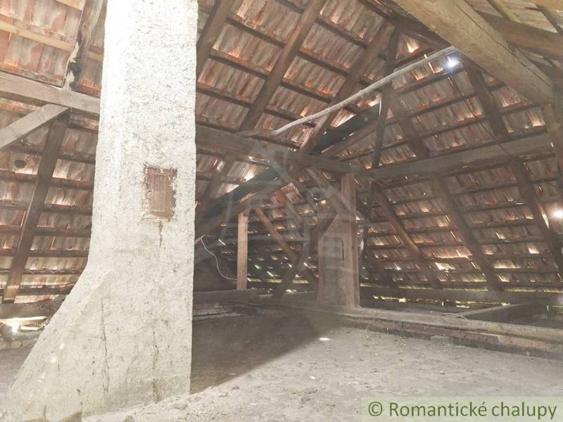 Pôvodný domček v obci Nová Vieska - Podkrovie rodinného domu v Nových Zámkoch s drevenými trámami a šikmou strechou.