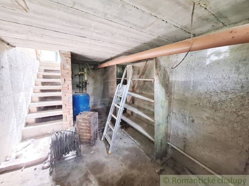 Pôvodný domček v obci Nová Vieska - Suterén rodinného domu v Novej Vieske s kovovým rebríkom a nádržou na vodu.