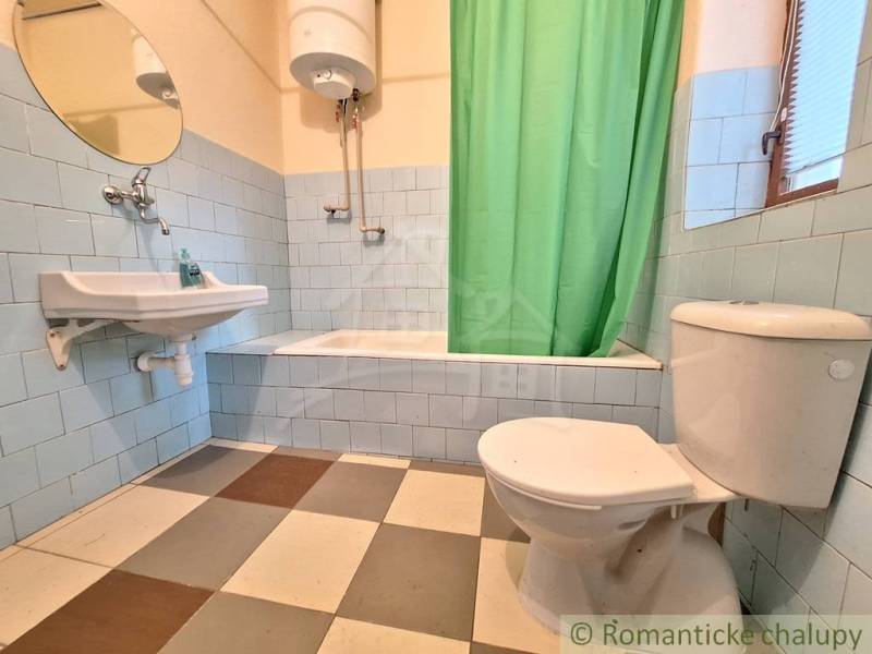 Pôvodný domček v obci Nová Vieska - Kúpeľňa v rodinnom dome s vaňou, umývadlom, toaletou a dlažbou v šachovnici.