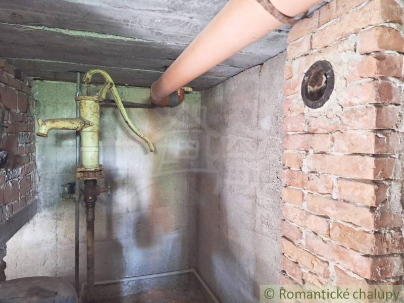 Pôvodný domček v obci Nová Vieska - Tehlová stena a vodná pumpa v suteréne rodinného domu.