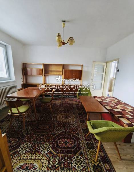 Predaj rodinného domu, Seredská, Seredská, Hlohovec - Rodinný dom so starožitným nábytkom, kobercom s farebnými vzormi a zelenými stoličkami.