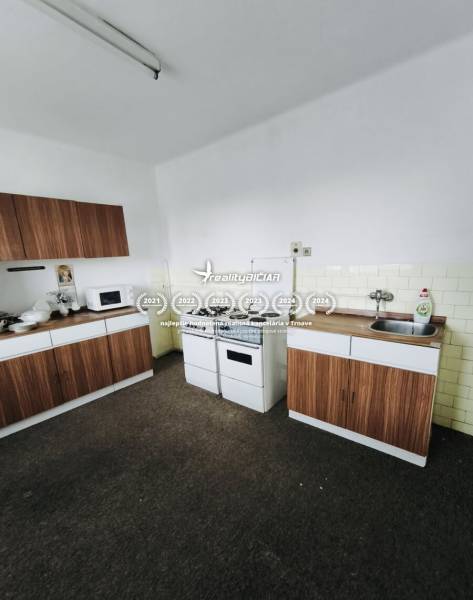 Predaj rodinného domu, Seredská, Seredská, Hlohovec - Kuchyňa s plynovým sporákom, mikrovlnkou a skrinkami v rodinnom dome s dreveným dekorom.