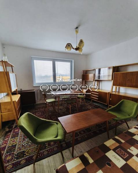 Predaj rodinného domu, Seredská, Seredská, Hlohovec - Obývacia izba v rodinnom dome s retro nábytkom a podlahou s dreveným dekorom.