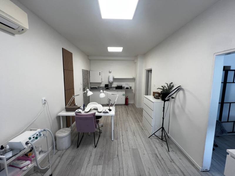 Prenájom ordinácie v zdravotnom stredisku Saratovská 24, Bratislava. - Obchodné priestory s podlahou s dreveným dekorom, nábytok, pracovný stôl a osvetlenie.