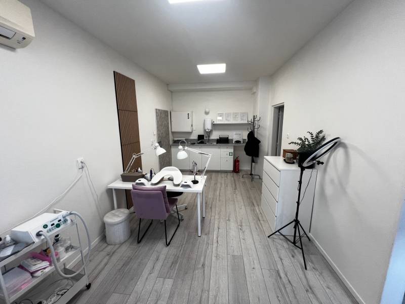 Prenájom ordinácie v zdravotnom stredisku Saratovská 24, Bratislava. - Obchodné priestory s pracovnými stolmi, kreslami, svetlami a podlahou s dreveným dekorom.