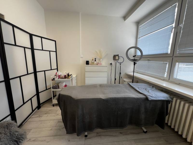 Prenájom ordinácie v zdravotnom stredisku Saratovská 24, Bratislava. - Kozmetická miestnosť s ošetrovacím stolom a podlahou s dreveným dekorom v obchodných priestoroch.