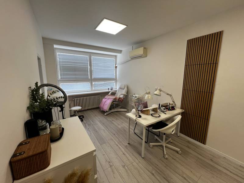 Prenájom ordinácie v zdravotnom stredisku Saratovská 24, Bratislava. - Kozmetický salón s podlahou s dreveným dekorom, bielym nábytkom a jemným osvetlením.