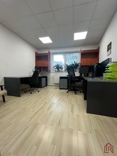 Investičná príležitosť: Polyfunkčná budova 1 000m², Košice-Staré mesto - Kancelária v budove s drevenou podlahou, stolmi a stoličkami.