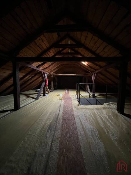 Investičná príležitosť: Polyfunkčná budova 1 000m², Košice-Staré mesto - Podkrovie s dreveným stropom a nosníkmi, osvetlené malým oknom v budove.