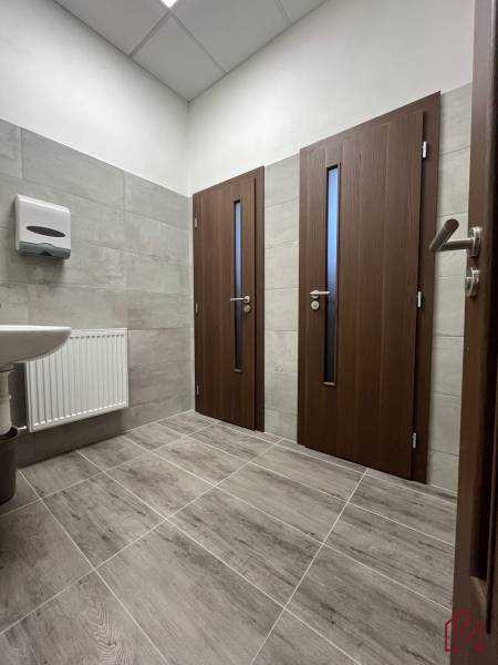 Investičná príležitosť: Polyfunkčná budova 1 000m², Košice-Staré mesto - Interiér budovy s dlažbou, dvermi a umývadlom, jednoduchý dizajn.