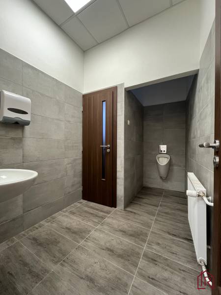 Investičná príležitosť: Polyfunkčná budova 1 000m², Košice-Staré mesto - Kúpeľňa v budove s umývadlom, pisoárom, dverami a obkladom z dlaždíc.