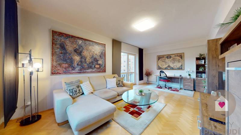 BA/STARÉ MESTO - Prenájom kompletne zariadeného 2i bytu s 2 balkónmi - Obývacia izba 2-izbového bytu s podlahou s dreveným dekorom, pohovkou a pracovným stolom.