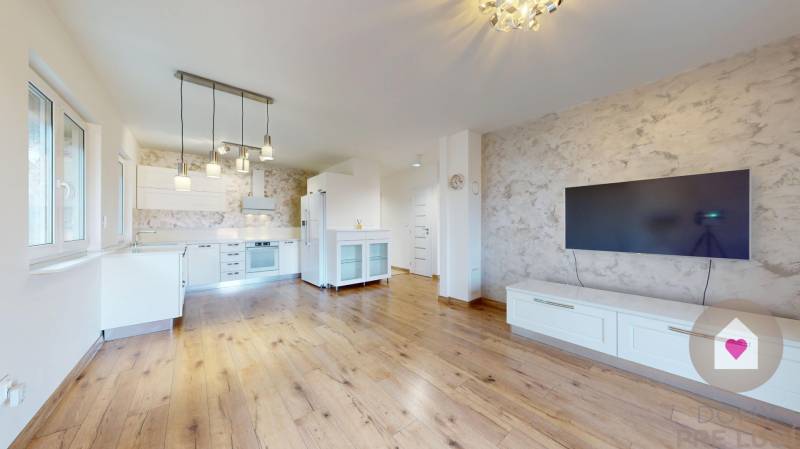 MALÉ LEVÁRE-Predaj  3i modernej novostavby RD s tep. čerpadlom + garáž - Kuchyňa a obývačka s podlahou s dreveným dekorom a televízorom v Rodinnom dome.