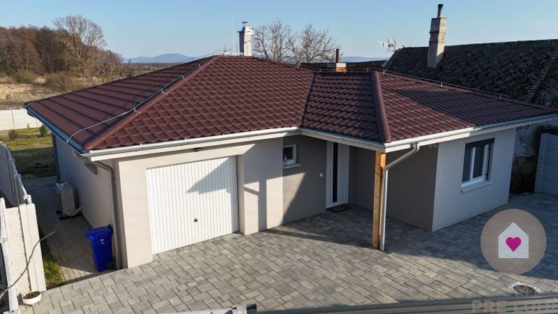 MALÉ LEVÁRE-Predaj  3i modernej novostavby RD s tep. čerpadlom + garáž - Rodinný dom v Malých Levároch na ulici Malé Leváre s hnedou strechou a garážou.