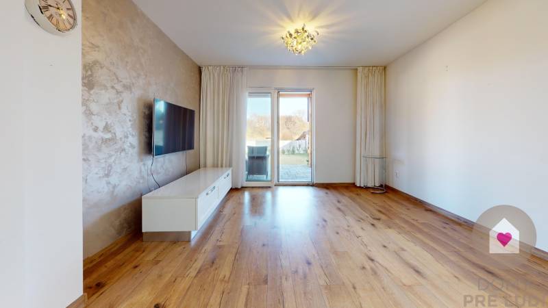 MALÉ LEVÁRE-Predaj  3i modernej novostavby RD s tep. čerpadlom + garáž - Obývacia izba s televízorom, podlahou s dreveným dekorom a prístupom na terasu v rodinnom dome.