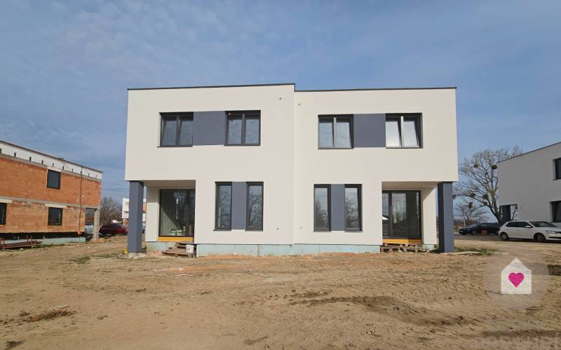 4 izbový RD-128 m2 S TEP. ČERPADLOM, POZEMOK 405m2 - Rodinný dom na Jazerná ulici v Zálesí s minimalistickou fasádou a veľkými oknami.