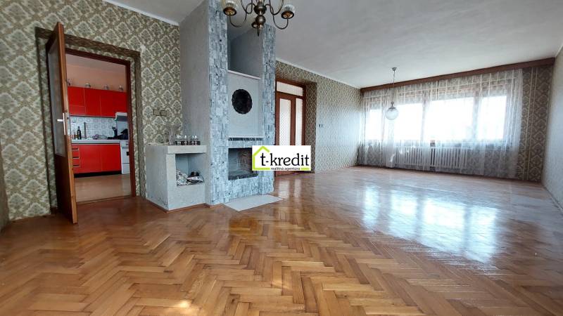 PREDAJ - RODINNÝ DOM - ZLATÉ MORAVCE - Obývacia izba v rodinnom dome s krbom a podlahou s dreveným dekorom.