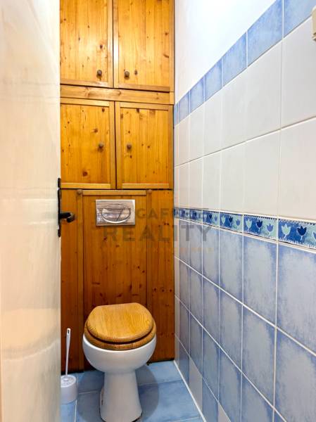 PRENÁJOM 1 izbový byt, 40 M2, Bratislava, Ružinov, Košická ulica, NIVY - Toaleta s dreveným obkladom a modro-bielymi obkladačkami v 1-izbovom byte.