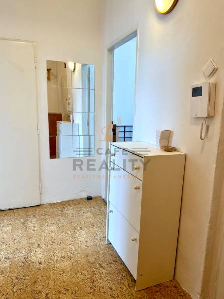 PRENÁJOM 1 izbový byt, 40 M2, Bratislava, Ružinov, Košická ulica, NIVY - Predsieň s bielym nábytkom, zrkadlom a svetlými stenami v 1-izbovom byte.