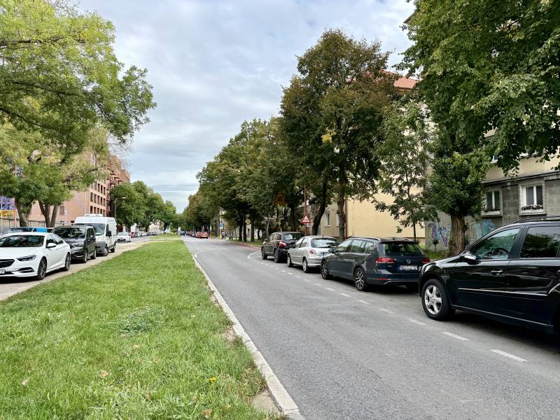 PRENÁJOM 1 izbový byt, 40 M2, Bratislava, Ružinov, Košická ulica, NIVY - Pohľad na zelený pás a cestu v Bratislave - Ružinove s autami a stromami.