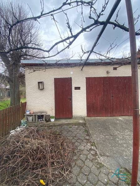 RD so záhradou, pivnicou garážou na Myjave.  - Rodinný dom na Turej lúke v Myjave s dvorom, stromami a drevenými dverami.