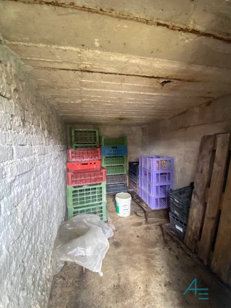 RD so záhradou, pivnicou garážou na Myjave.  - Skladový priestor v rodinnom dome obsahuje plastové debny a vedro.